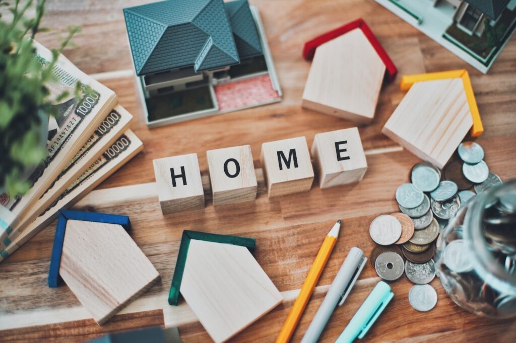 家の模型と日本円、文房具、HOMEの文字ブロック
